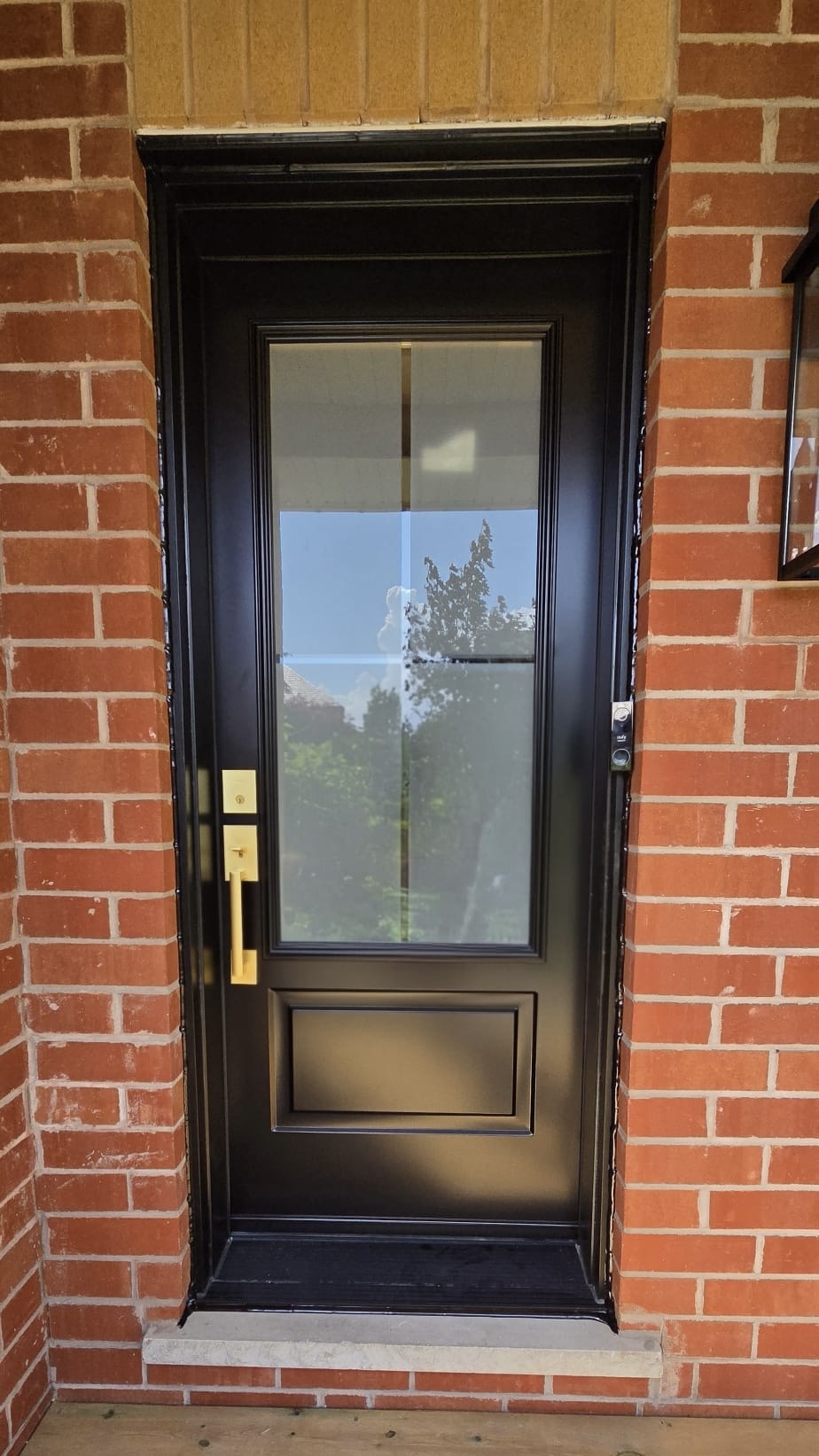 Front entry door in black with brushed brass handleset and smart lock