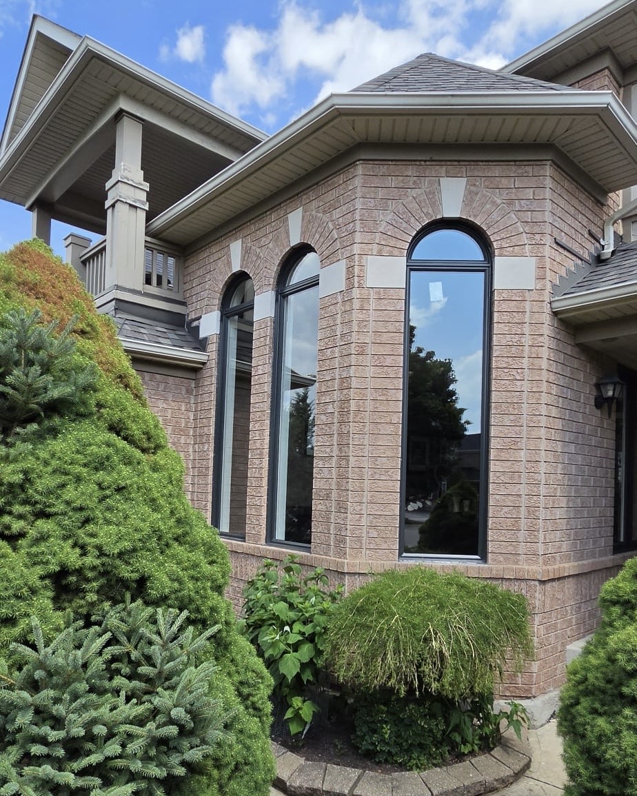 New black-framed custom arched windows installed in the turret bay