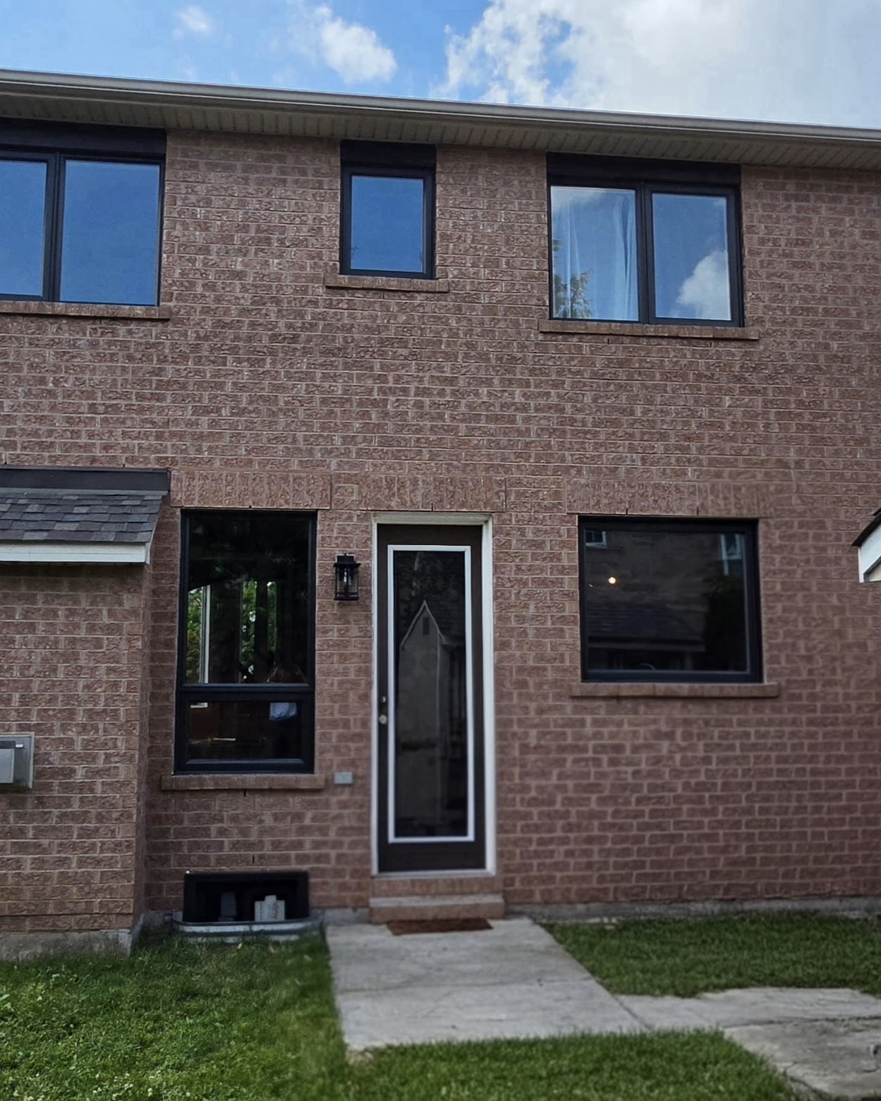 Completed rear elevation with black-framed windows and new entry door