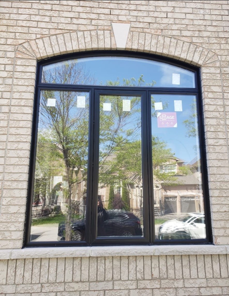Custom arch-top window with black frame and fixed arched transom