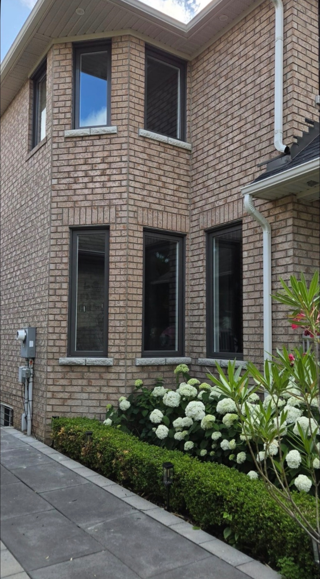 Black-frame casement windows on brick side elevation