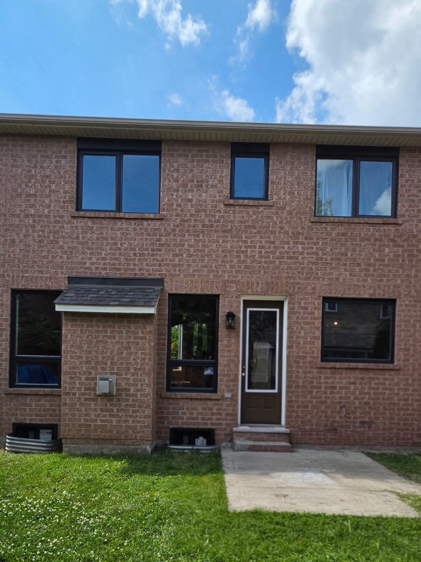 Full rear façade showing the finished black window package and entry system