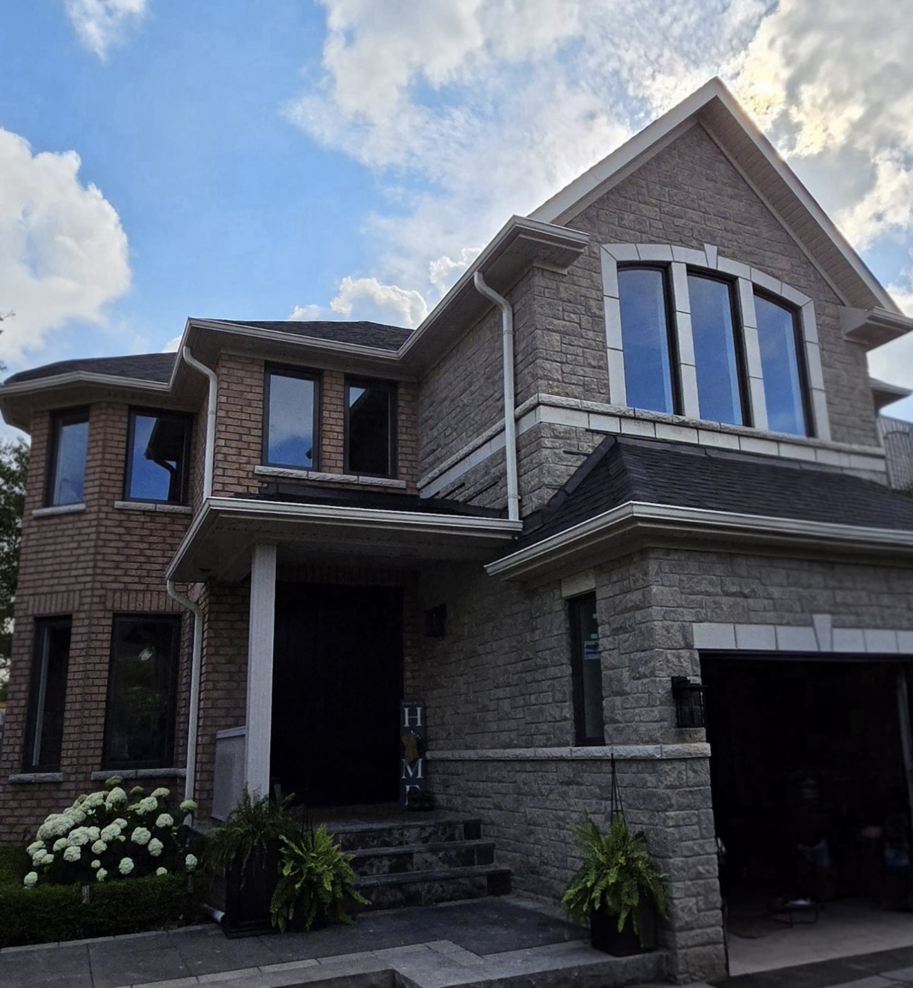 Full home window package on stone-and-brick two-storey