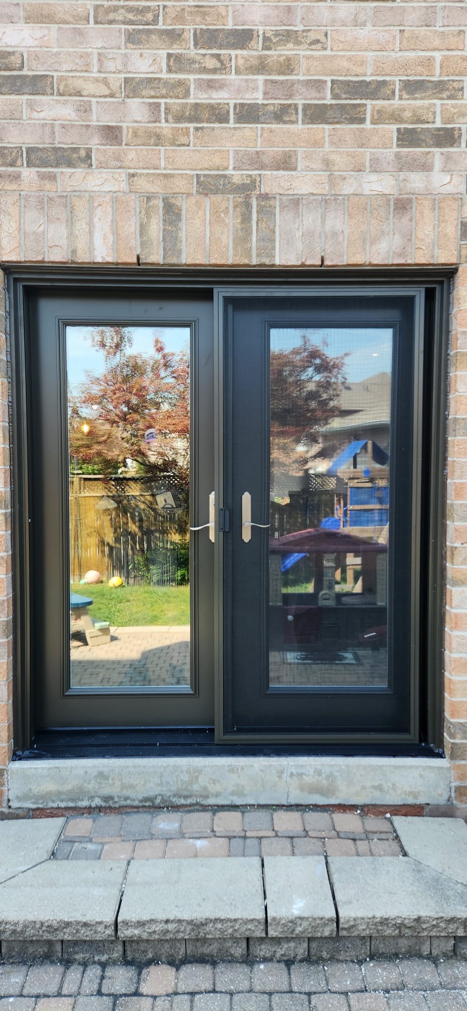 Black French patio doors with full-lite glass on brick
