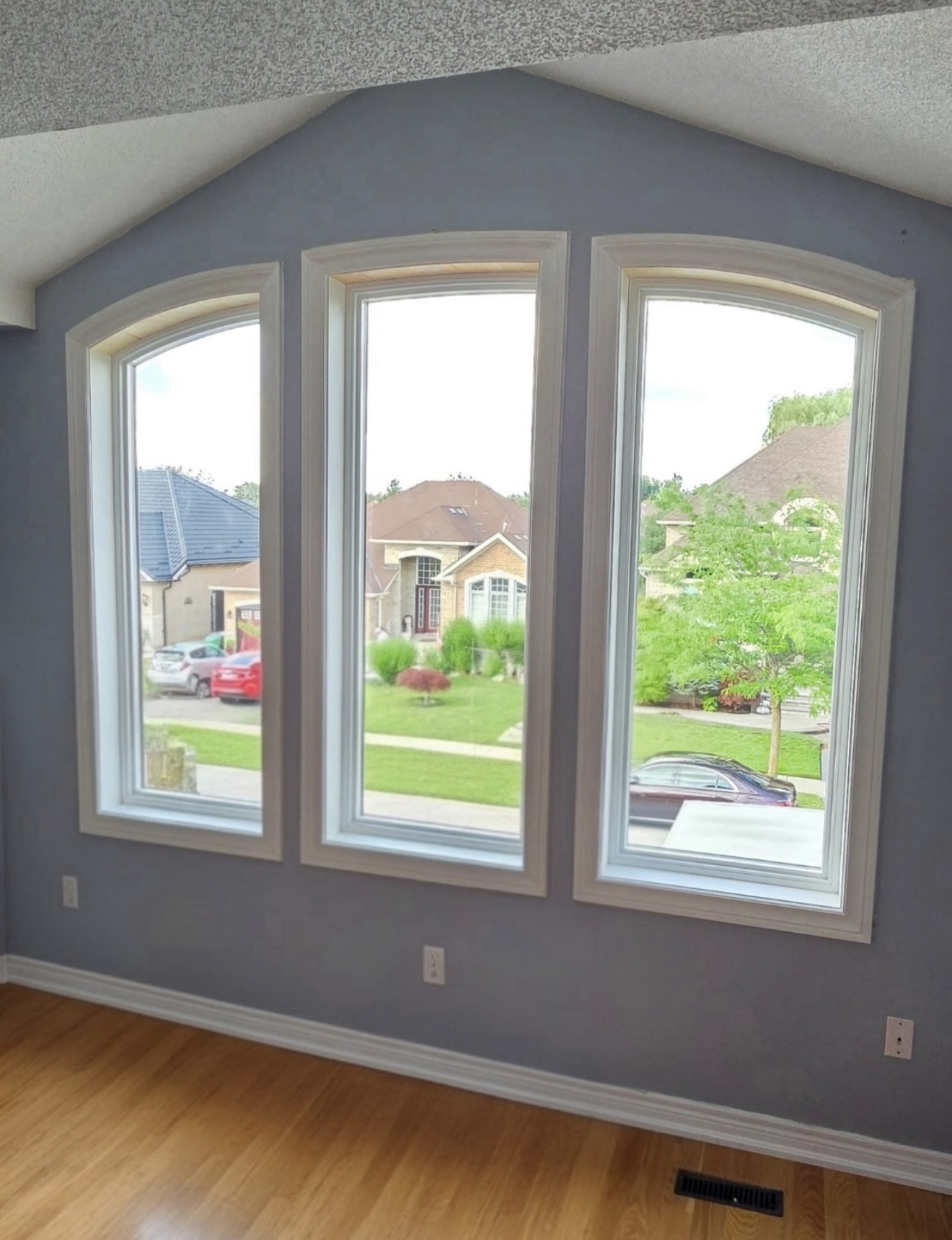 Three arched picture windows in a vaulted living room