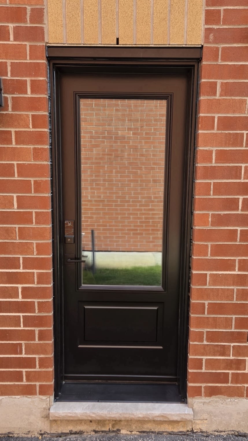 New black 3/4-lite steel entry door installed in red brick opening