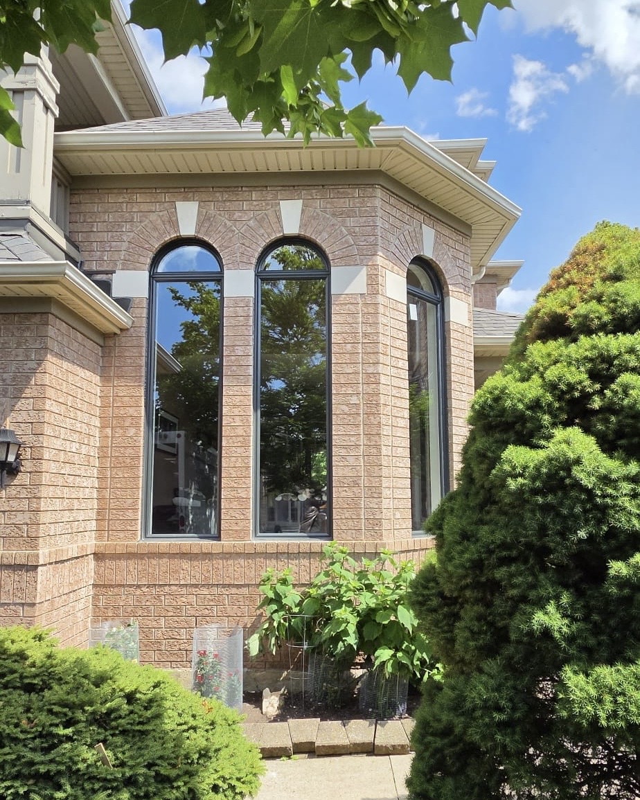 Angled exterior view of the finished black arched window bay