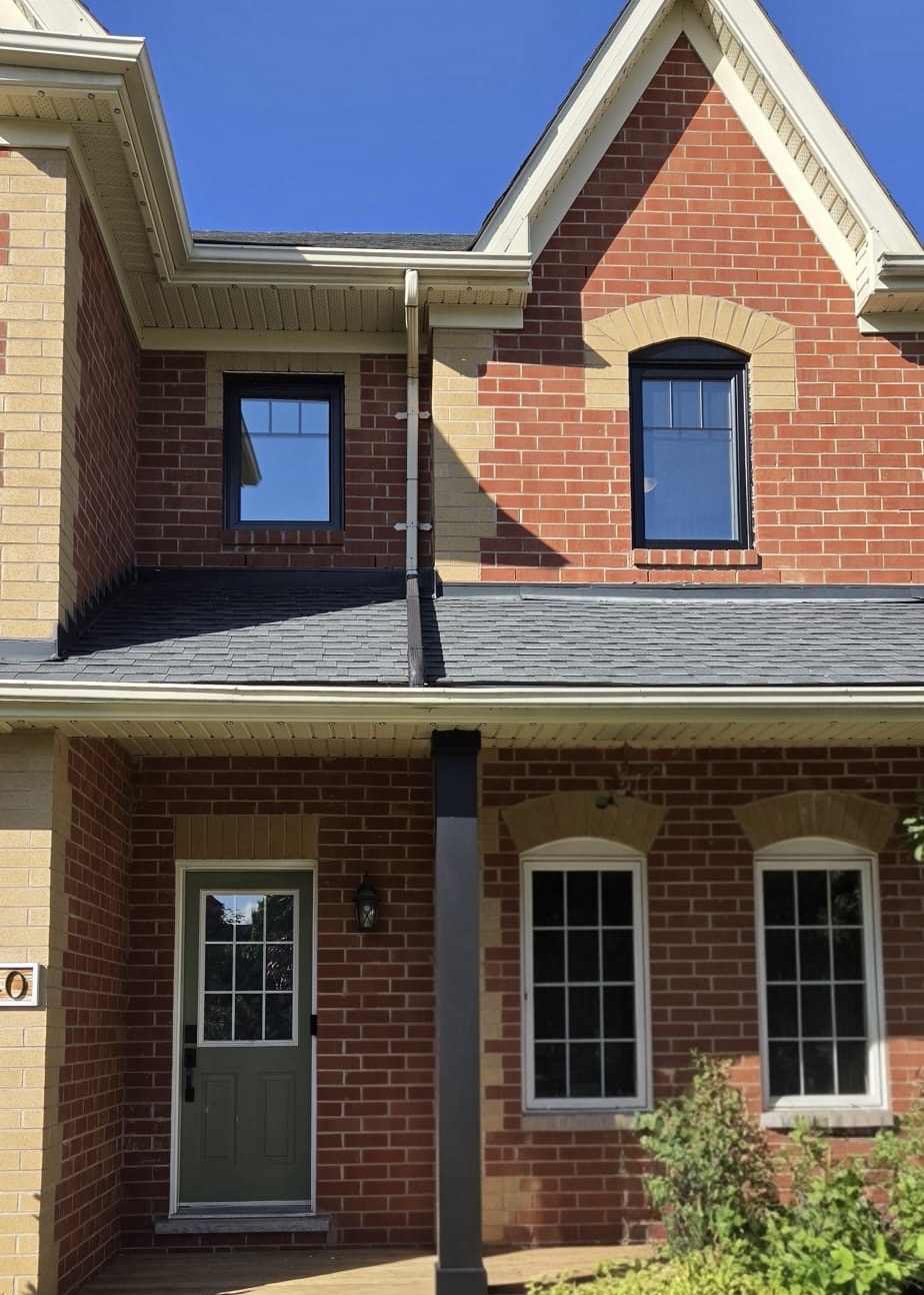 Detail of the gable arch-top window and porch windows in black frames